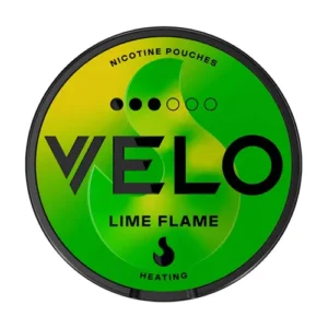 A direct top-down studio shot of a circular Velo Lime Flame Snus can framed by a sleek black rim. The lid features a vibrant, energetic gradient background shifting from bright yellow to deep lime green, visually evoking the zesty freshness of lime and the fiery kick of peppers described in the article. The brand name "VELO" dominates the centre in bold black typography. Above the logo, a strength indicator displays three solid black dots out of six, visually marking the product's normal strength. Below the branding, the text "LIME FLAME" is printed, accompanied by a stylized flame icon and the word "HEATING" at the bottom, reinforcing the unique taste experience that balances heat and tang.